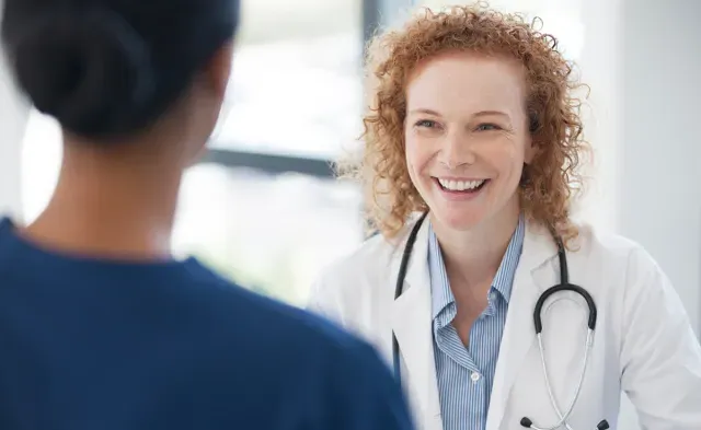 Public Health Nurse Smiling with Patient in Office